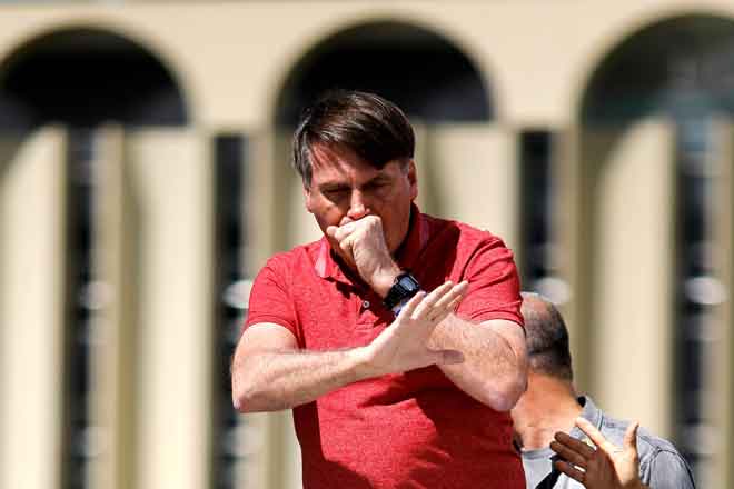  Gambar fail diambil pada 19 April lepas menunjukkan Bolsonaro batuk ketika berucap selepas menyertai penyokongnya yang membantah langkah kuarantin dan penjarakan sosial untuk membendung penularan pandemik COVID-19 di Brasilia. — Gambar AFP