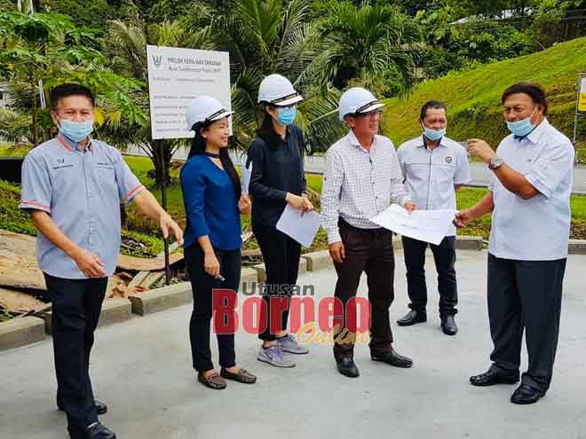  Mawan (kanan) mendingka penerang ari Penulung Injinir Divisyen Opis Kereja Raya Sarikei, Frasser George Michael sereta dikemataka sida ke bukai maya ngabas Projek Mit Menua pesisir Pintu Penama Pakan.