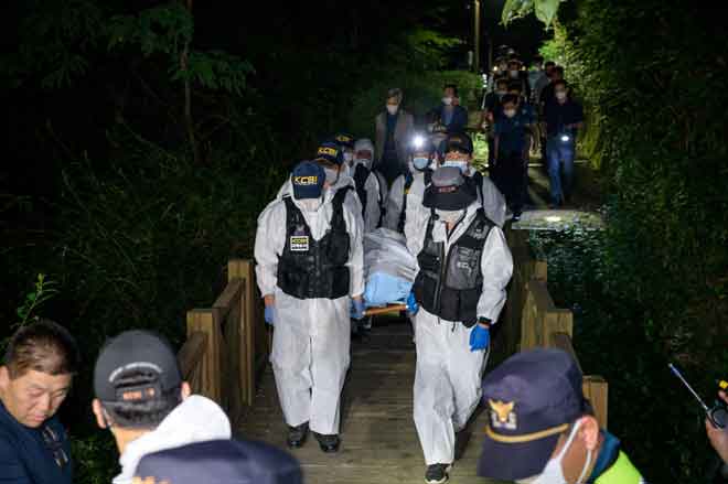  Pasukan forensik polis mengangkat mayat Park (sisipan) yang ditemui maut beberapa jam selepas dilaporkan hilang di sebuah taman di Seoul semalam. — Gambar AFP