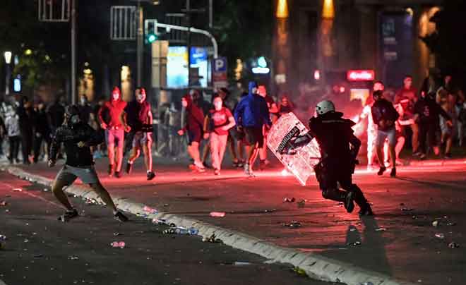  Polis bertempur dengan penunjuk perasaan yang membantah pengumuman perintah berkurung hujung minggu untuk membendung COVID-19 berhampiran bangunan Dewan Negara di Belgrade kelmarin. — Gambar AFP