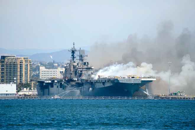  Gambar serahan Tentera Laut AS menunjukkan bot jabatan polis dan bomba pelabuhan cuba memadam api di atas USS Bonhomme Richard di Pangkalan Tentera Laut San Diego, kelmarin. — Gambar AFP