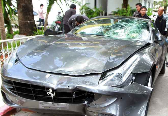  Gambar fail 3 September 2012 menunjukkan polis memeriksa kereta Ferrari yang                dipercayai terlibat dalam kejadian langgar lari di balai polis Thong Lor di Bangkok. — Gambar AFP