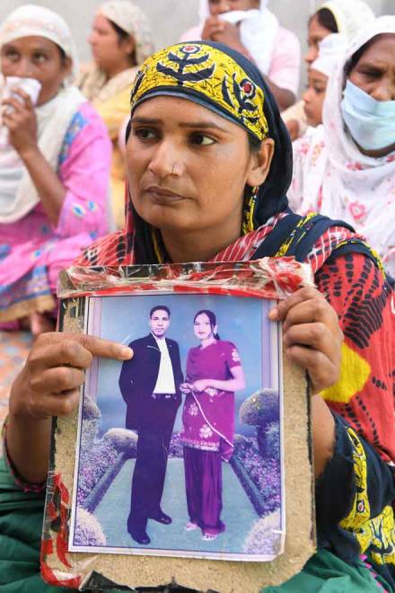  Paramjit Kaur menunjukkan gambar suaminya Joga Singh yang merupakan salah seorang mangsa todi beracun di kampung Muchhal, 30km dari Amritsar, kelmarin. — Gambar AFP