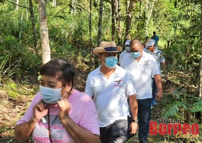 Henry (dua depan) berjalan kaki bagi meninjau lokasi serta tapak baru untuk pembinaan SK Suba Buan di Bau, Sabtu lepas. 