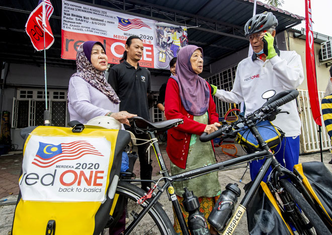  Wan Hashim (kanan) bersama ibunya Hasmah Ahmad, 88, (dua kanan) dan isteri Faridah Daud, 68, (kiri) sebelum memulakan Kayuhan Solo Merdeka 2020 di hadapan rumahnya di Jalan Telipot di Kota Bharu, semalam. — Gambar Bernama