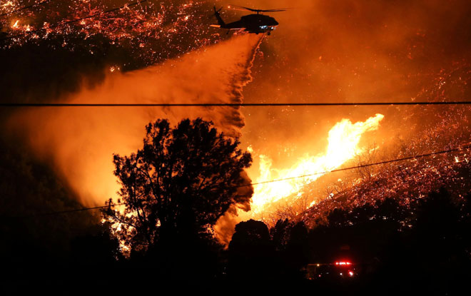  Helikopter bomba mencurah air untuk memadam kebakaran hutan di Lake Hughes, California kelmarin. — Gambar AFP