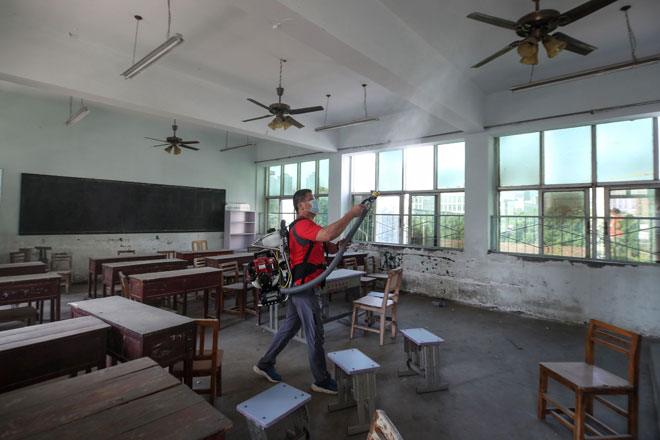  Seorang sukarelawan menyembur bahan nyahkuman di sebuah bilik darjah sebuah sekolah sebelum bermulanya semester baharu di Handan di wilayah Hebei, China. — Gambar AFP