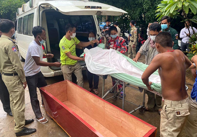  Saudara mara mengangkat mayat Kaing Guek Eav (sisipan) dari ambulans untuk upacara pengebumian di sebuah pagoda di Phnom Penh semalam. — Gambar AFP