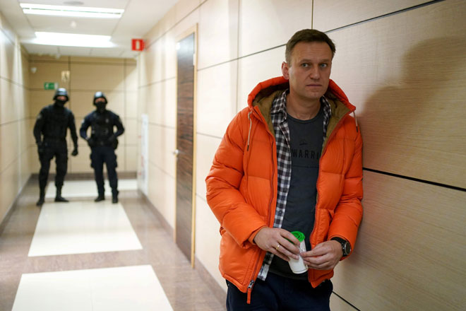  Gambar fail diambil pada 26 Disember, 2019 menunjukkan Alexei Navalny               berdiri berhampiran dengan ejen penguat kuasa undang-undang di ruang depan sebuah pusat perniagaan yang menempatkan pejabatnya, Yayasan Anti-Rasuah (FBK), di Moscow. — Gambar AFP