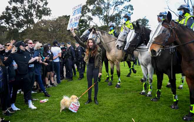  Pembantah berhadapan dengan polis di Tugu Peringatan di Melbourne kelmarin, ketika rali protes anti sekatan pergerakan yang dikuatkuaskan oleh pihak kerajaan bagi mengekang penularan COVID-19. — Gambar AFP