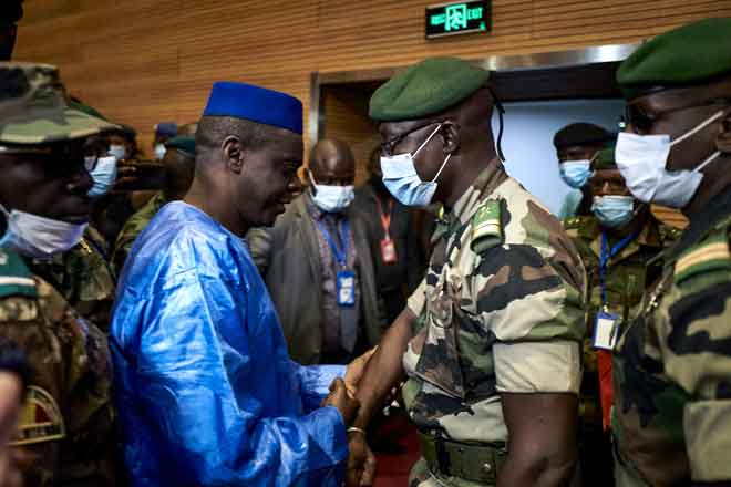  Kolonel Malick Diaw (kanan) bersalaman dengan Issa Kaou Djim, tokoh Pegerakan 5 Jun, pada upacara dialog di  Mali, Bamako kelmarin. — Gambar  AFP