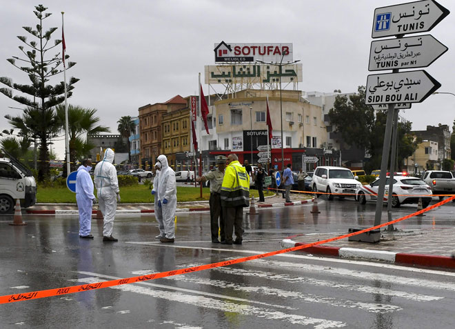  Anggota polis forensik memeriksa tempat kejadian yang menyaksikan seorang pegawai maut dan seorang lagi cedera di Sousse, selatan Tunis kelmarin. — Gambar AFP