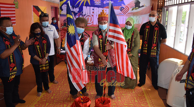  Saifuddin (tiga kanan) bersama Tuai Rumah Akat memacak Jalur Gemilang sebagai simbolik perasmian Program Merdeka@Komuniti di Rumah Akat Akong, Penasu, Sibu, semalam.