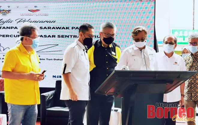 Abang Johari (tiga kanan) melakukan simbolik pelancaran Transaksi Tanpa Tunai Sarawak Pay dan Rangkaian Wifi sambil diperhatikan (dari kiri) Sim, Zaidi, Ting, Jaul dan Dr Annuar.