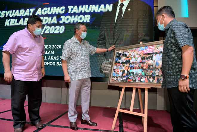   Hasni menerima cenderahati daripada Presiden Kelab Media Johor Mohd Fauzi Ishak (kanan) pada majlis perasmian Mesyuarat Agung Tahunan Kelab Media Johor 2019/2020, Johor Bahru malam kelmarin. Hadir sama Pengerusi Jawatankuasa, Pendidikan, Penerangan, Warisan dan Budaya Negeri Johor Mazlan Bujang (kiri). — Gambar Bernama