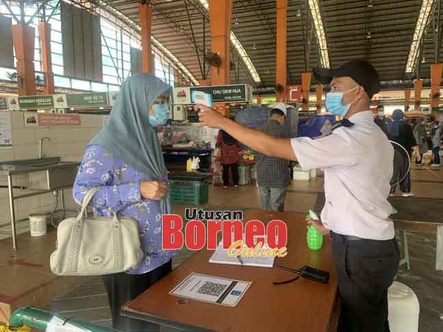  Pengawal keselamatan Mohd Zulfikrin Suria memeriksa suhu badan pelanggan sebelum dibenarkan masuk ke MNS.