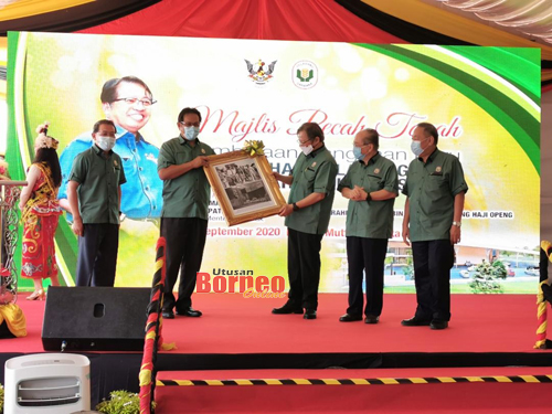 Abang Johari menerima cenderamata daripada Dr Abdul Rahman pada majlis pecah tanah Pembinaan Bangunan Baharu PPNS di Kota Samarahan. - Gambar oleh Roystein Emmor