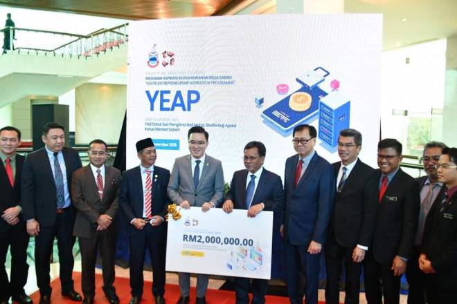  Shafie menyerahkan replika cek berbilang RM2 juta kepada Phoong (empat, kiri) pada Majlis Pelancongan Dana Keusahawanan YEAP di Dewan Undangan Negeri Sabah pada 19 November 2019.