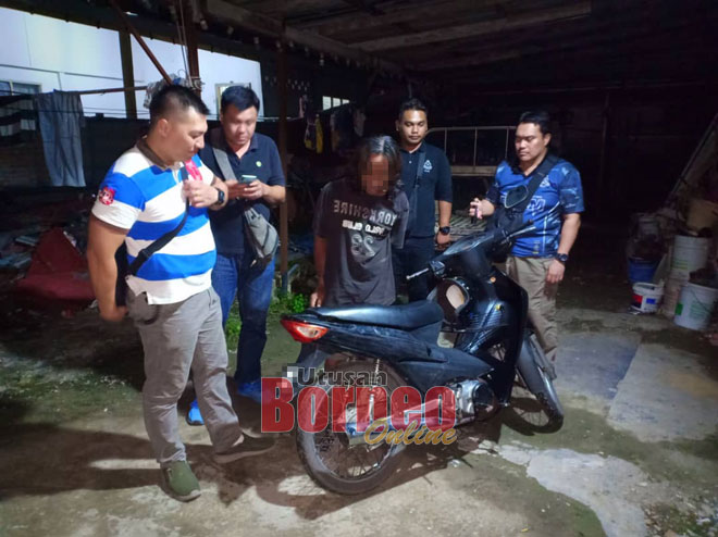  Salah seorang suspek yang berjaya ditangkap polis bersama sebuah motosikal yang disyaki dicuri. 
