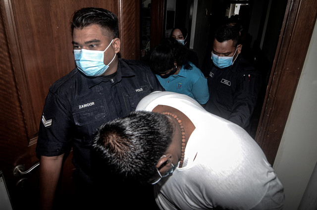 Saravanan Kumar (depan) dan Gayathry (belakang) diiringi anggota polis di Mahkamah Tinggi hari ini selepas didapati bersalah membunuh seorang kanak-kanak lelaki yang juga anak kepada tertuduh wanita pada 2014. - Gambar Bernama