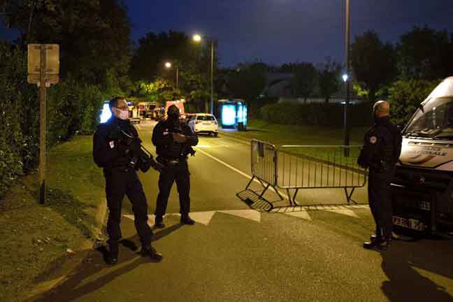  Anggota polis mengadakan sekatan di jalan raya di tempat berlakunya kejadian tembak mati yang dipercayai suspek kepada pembunuhan seorang guru di Conflans-Sainte-Honorine, Paris. — Gambar AFP