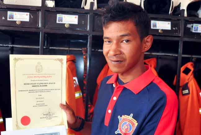  Mohamad Najmi menunjukkan sijil penghargaan yang diterima daripada Jabatan Bomba dan Penyelamat Malaysia (JBPM) Besut pada 14 Oktober lepas di Jerteh. — Gambar Bernama