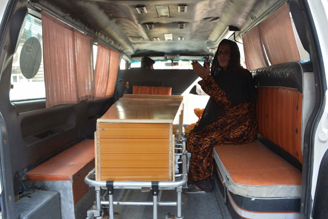  Seorang wanita duduk di sebelah keranda ahli keluarganya yang terbunuh dalam insiden rempuhan di Jalalabad, semalam. — Gambar AFP