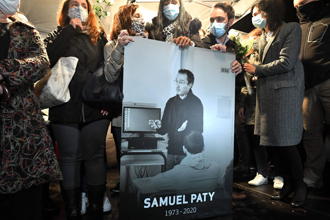  Orang ramai yang bersimpati membawa gambar Samuel Paty semasa perhimpunan                 di Conflans-Sainte-Honorine, barat laut Paris kelmarin. — Gambar AFP