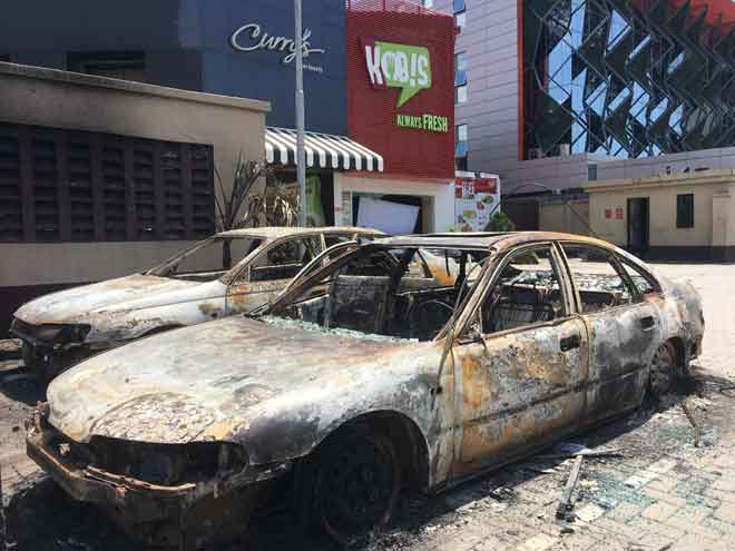  Dua kereta rosak selepas dibakar penunjuk perasaan yang menyerang pusat beli-belah kelas pertengahan di Lekki Phase 1, Lagos kelmarin. — Gambar AFP