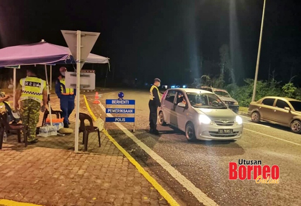  Pihak polis yang dibantu oleh anggota RELA dan Angkatan Pertahanan Awam Malaysia memeriksa sebuah kenderaan dalam Sekatan Jalan Raya di Telupid.