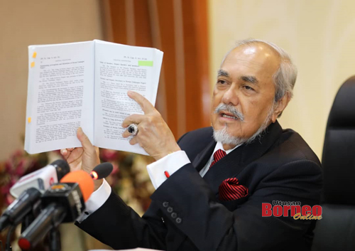 Asfia menunjukkan Perlembagaan Negeri Sarawak mengenai tempoh DUN Sarawak. - Gambar Chimon Upon