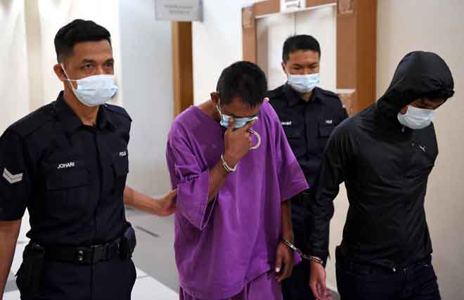 Mohd Irwan dan Rahim diiringi anggota Polis ketika keluar dari Mahkamah Sesyen Kuantan semalam selepas menghadapi pertuduhan ke atas mereka. — Gambar Bernama