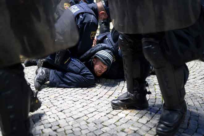 Anggota polis menangkap penunjuk perasaan yang bertelingkah dengan polis           semasa protes terhadap sekatan pergerakan COVID-19 yang dilaksanakan oleh kerajaan                             di Ljubljana kelmarin. — Gambar AFP 