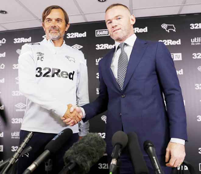  Gambar fail 2019 ini menunjukkan Rooney (kanan) berjabat tangan dengan pengurus Derby, Phillip Cocu semasa sidang media mengenai persetujuan Rooney untuk menjadi pemain-jurulatih  di Stadium Pride Park di Derby. — Gambar AFP