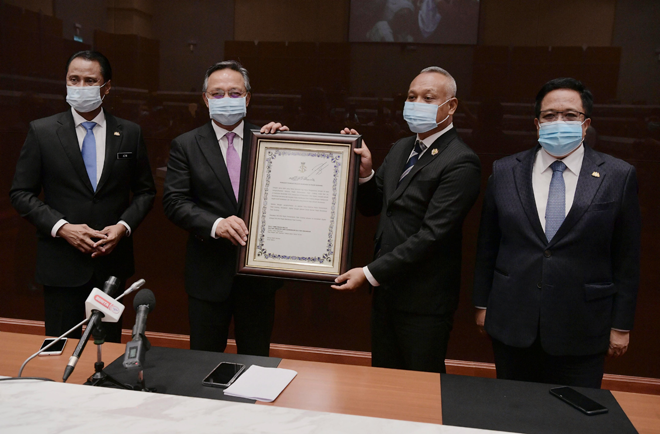  Hasni menyerahkan watikah pengisytiharan Majlis Perbandaran Pasir Gudang kepada Asman (dua kanan) pada majlis yang diadakan di Bangunan Dato’ Jaafar Muhammad, Kota Iskandar, Iskandar Puteri semalam. Hadir sama Pengerusi Jawatankuasa Perumahan dan Kerajaan Tempatan Ayub Jamil (kanan) dan Setiausaha Kerajaan Negeri Johor Datuk Azmi Rohani (kiri). — Gambar Bernama