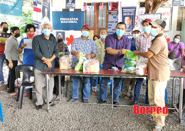  Nizam (tengah) menyampaikan bantuan bakul makanan kepada penduduk di Batu Payung.