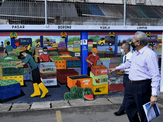 Annuar melihat hasil lukisan mural dan grafiti ketika hadir pada majlis penyampaian hadiah Pertandingan Mural dan Grafiti Transformasi Pasar Borong Kuala Lumpur di Pasar Borong Kuala Lumpur, di ibu negara semalam. — Gambar Bernama