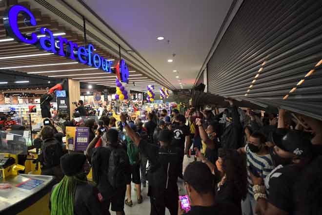  Penunjuk perasaan menceroboh pasar raya Carrefour di Sao Paulo, Brazil pada Jumaat lepas untuk membantah tindakan pengawal keselamatan memukul sehingga mati seorang lelaki kulit hitam. — Gambar AFP