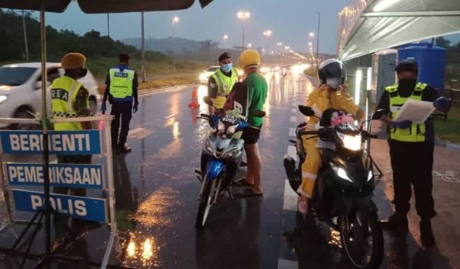 Anggota penguatkuasa yang terlibat semasa operasi sekatan jalan raya sempena PKPB di Batu 15 Jalan Kuching-Serian. 