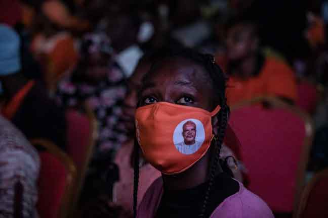  Penyokong memakai pelitup muka yang terpapar gambar Kabore semasa meraikan kemenangannya dalam pilihan raya dan kekal sebagai presiden Burkina Faso untuk penggal kedua di Ibu Pejabat MPP di Ouagadougou, kelmarin. — Gambar AFP
