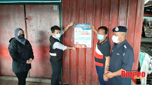   Mohd Azhar (kanan) bersama Timbalan Presiden MPS, Farizah Giau (kiri) melihat sendiri  penampal poster 'Bersama Cegah Penyakit Covid - 19' oleh kakitangan kesihatan sempena operasi bersepadu di Kg Bahagia, Batu Sapi.