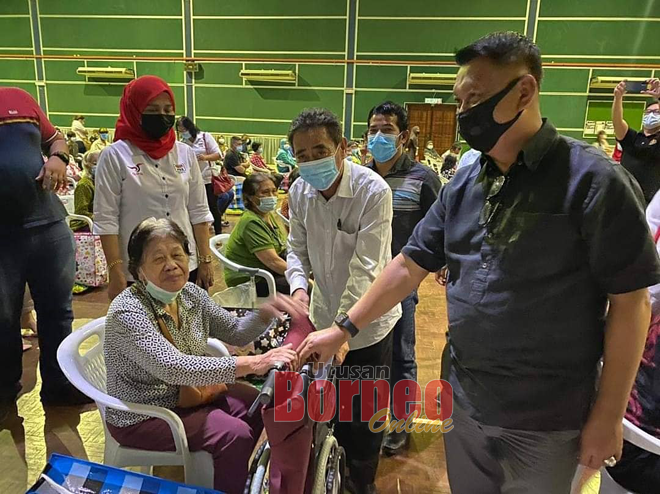  Awla (dua kiri) menyampaikan sumbangan kepada salah seorang penerima di bawah Program Ziarah Kamek Parlimen Batang Sadong. 