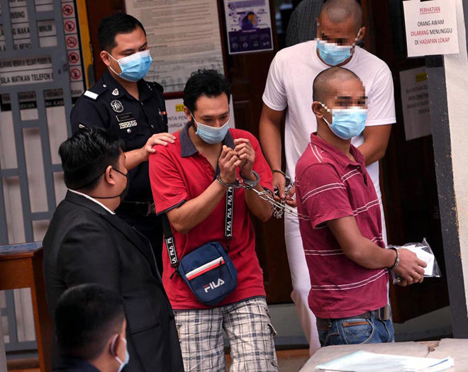  Mohd Zamidi diiringi anggota polis sebaik tiba di Mahkamah Majistret Kangar atas pertuduhan mengedar dadah jenis syabu dan ganja seberat 226 kilogram pada September lalu. — Gambar Bernama