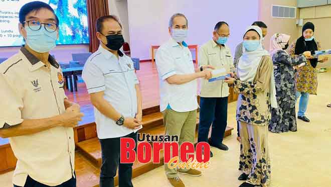  Wan Junaidi (tiga kiri) menyampaikan cek geran MRP kepada penerima pada satu majlis di Lundu, semalam.