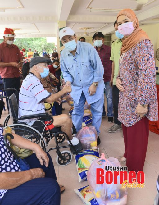  Hajiji (tengah) dan Juliah (kanan) menyampaikan sumbangan Krismas di majlis itu.