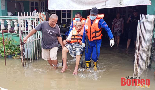 Anggota APM membantu memindahkan warga emas yang terjejas banjir. 