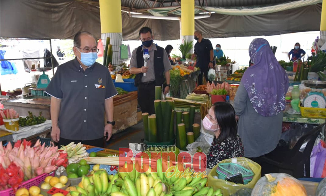  Uggah (kiba) berandau enggau siku pedagang ti bejual buah ba Pasar Kota Sentosa.