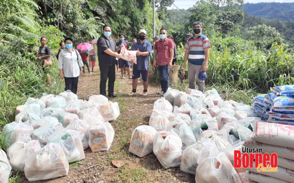 Hendrus (dua kiri) menyerahkan bantuan bakul makanan kepada penduduk kampung, dalam tinjauannya ke perkampungan dalam DUN Tandek. 