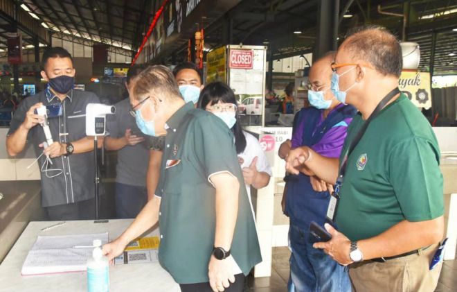  Uggah memeriksa buku pendaftaran pelanggan di Medan Selera Pasar Bandar Riyal.