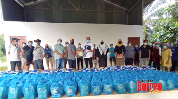  Ruddy (enam kiri) menyampaikan bantuan bakul makanan kepada penduduk kampung.